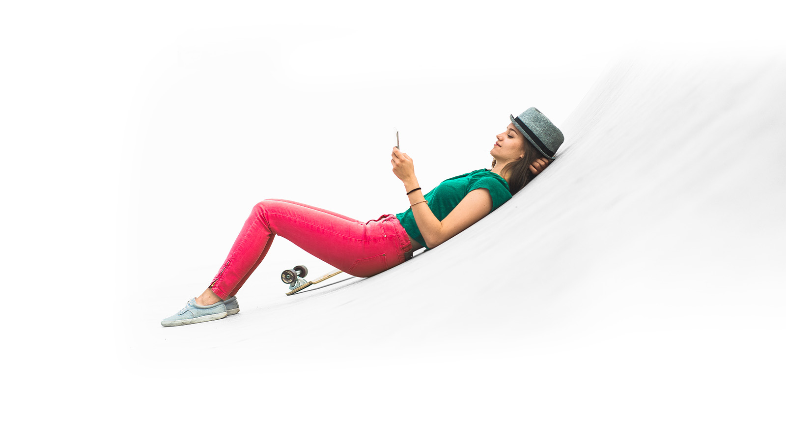 Frau liegend mit Handy und Skateboard