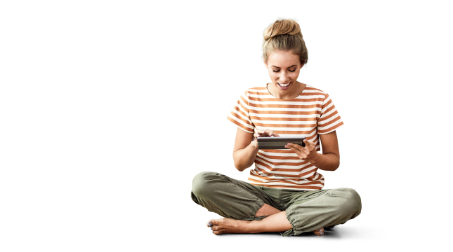Lachende Frau sitzt im Schneidersitz, hält ein Tablett in der Hand.
