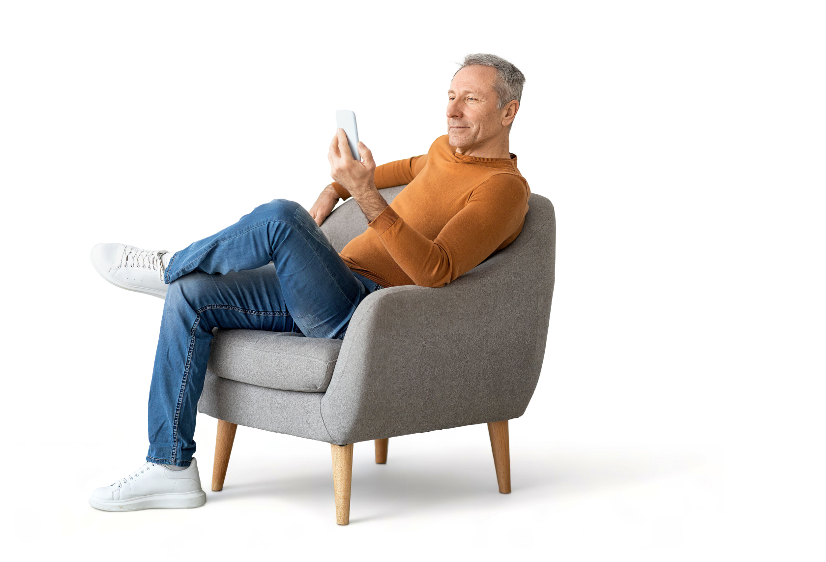 Mann sitzt entspannt im Sessel, hält ein Handy in der Hand.